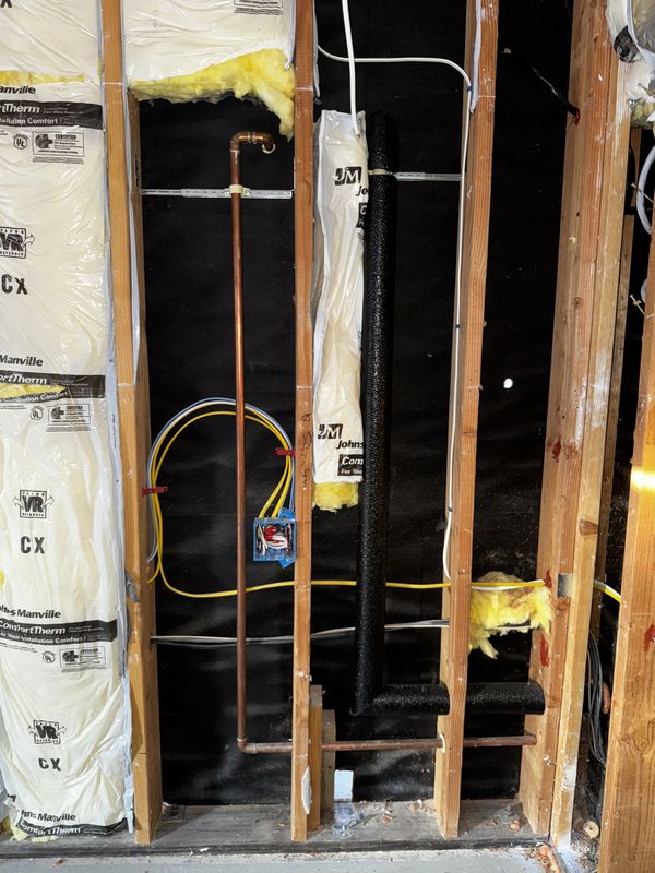 Copper water line and new wiring coordinated inside an open wall bay