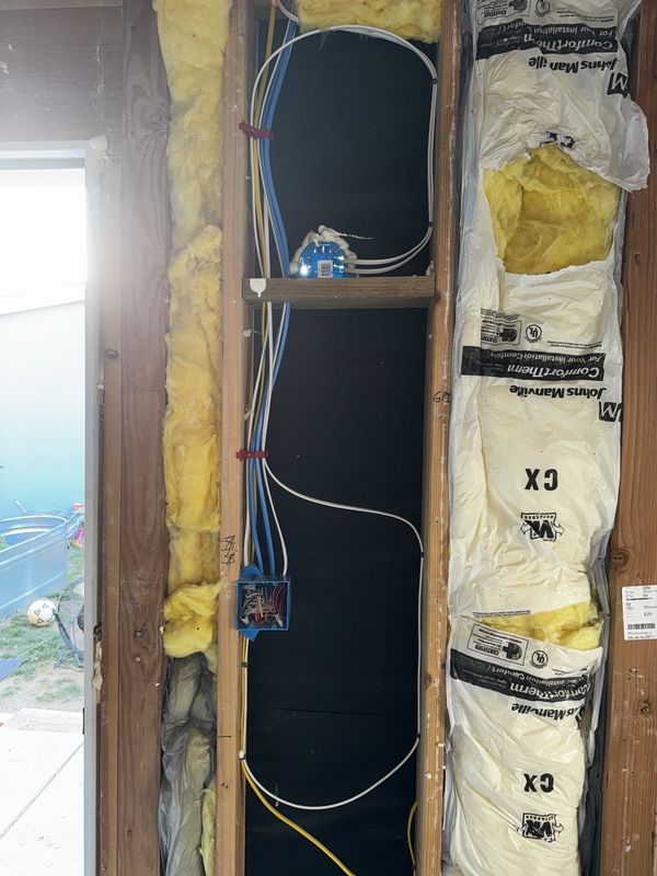 New circuits and junction box set in an open stud bay beside the door