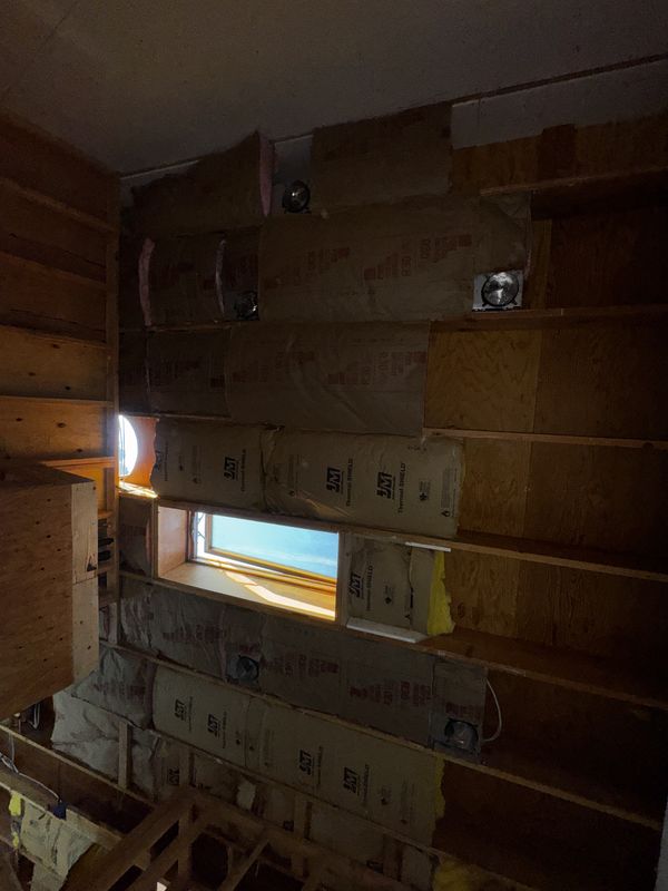 Insulated ADU walls with recessed light housings roughed in before drywall