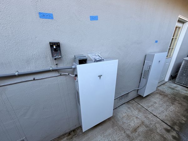 Tesla Powerwall units and gateway equipment on the exterior wall