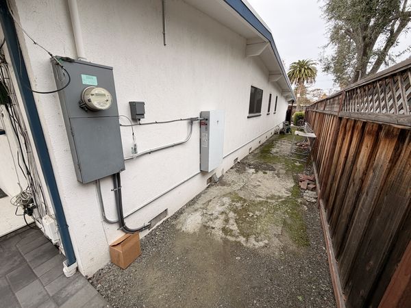 Side-yard view of meter, monitoring equipment, and battery cabinet