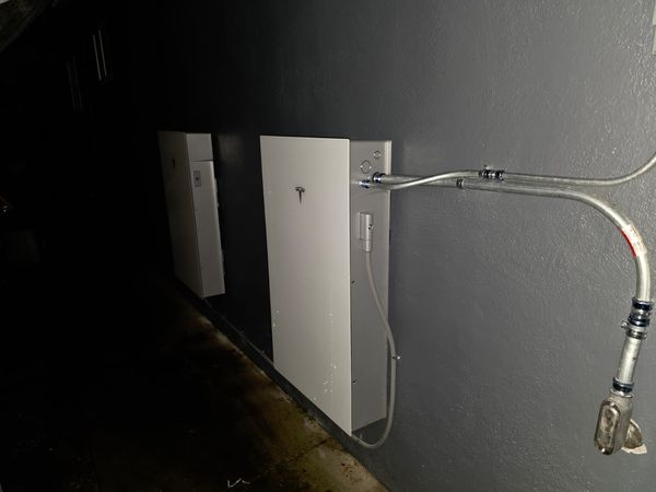 Backup battery cabinets installed with conduit along the exterior wall