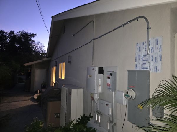 Evening view of the completed solar, battery, and backup equipment wall