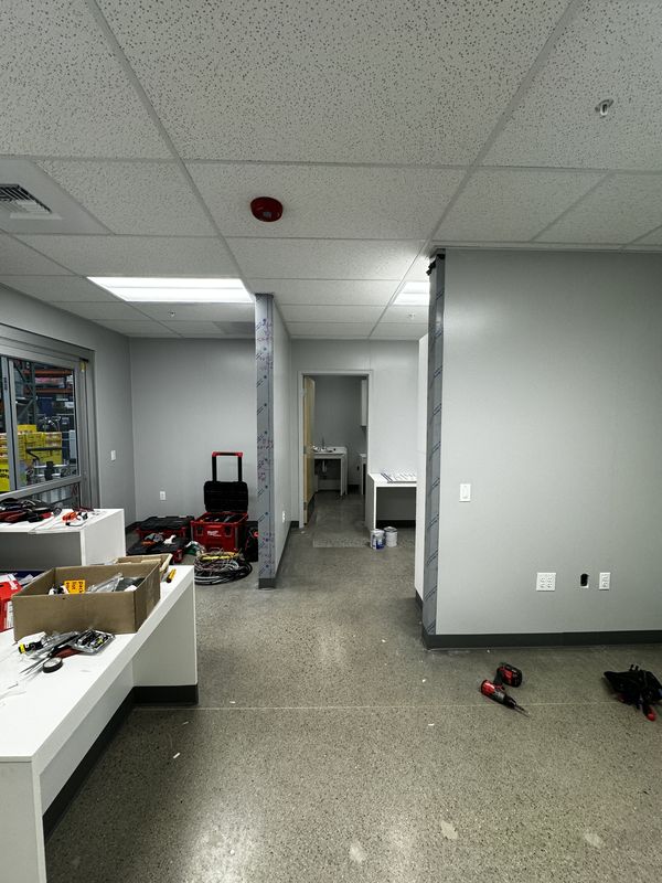 Finished office area with suspended ceiling lighting and fire alarm devices