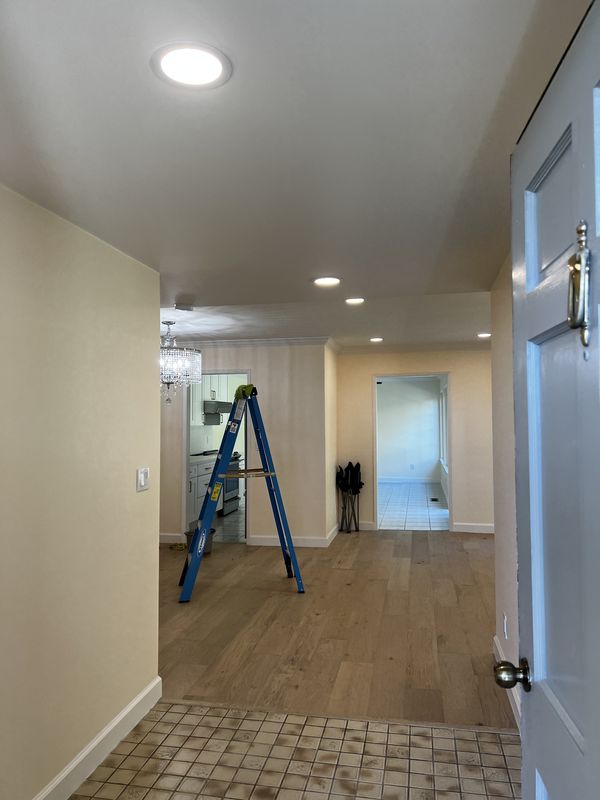 Entry hall with new recessed lighting during finish work on a whole-home rewire