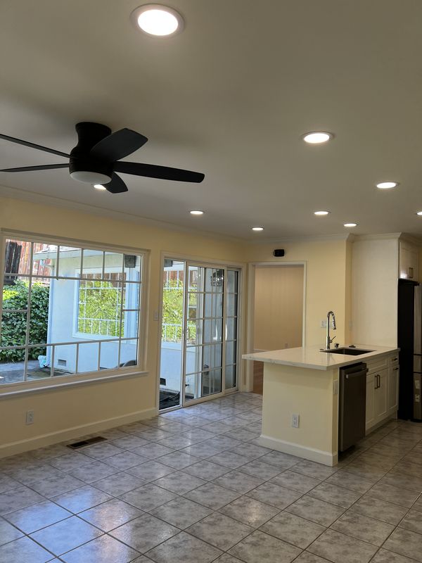 Family room with new flush-mount ceiling fan and recessed lighting beside sliding patio doors