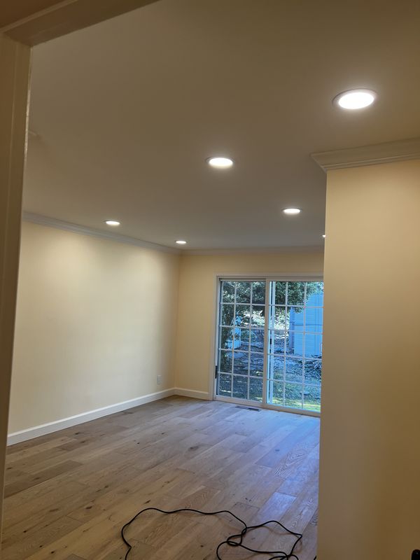 Living area with new recessed lighting and rewired circuits by the sliding glass door