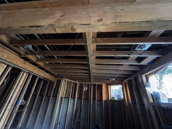 Ceiling joists with new wiring runs and recessed lighting rough-in