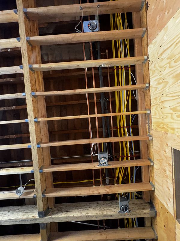 Ceiling bays with copper piping and new branch circuits routed through joists