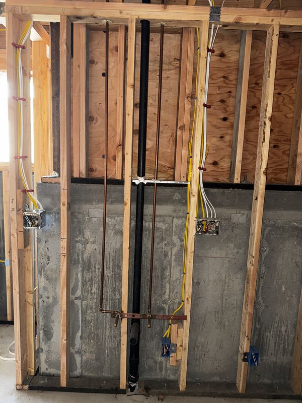 Basement wall with new circuits coordinated alongside copper and ABS plumbing