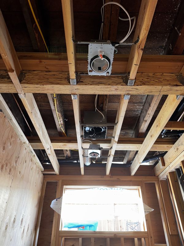 Recessed light housings, junction box, and duct rough-in above a window opening