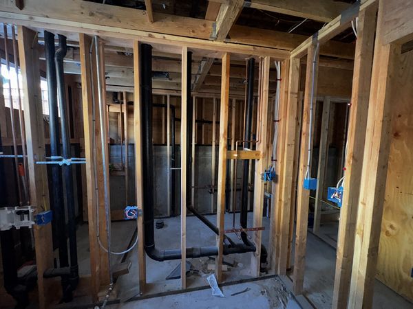 Open stud bays with junction boxes and piping during whole-home rough-in