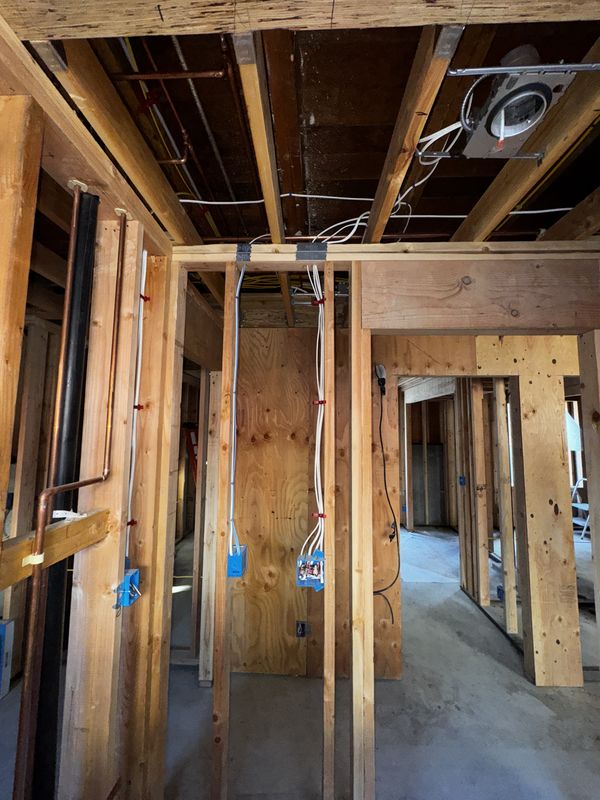 Doorway framing with new switch and receptacle runs stapled and protected
